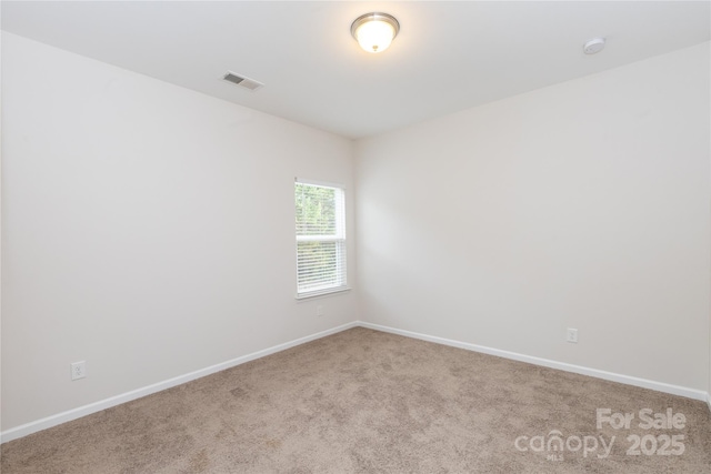 unfurnished room featuring baseboards, visible vents, and carpet flooring