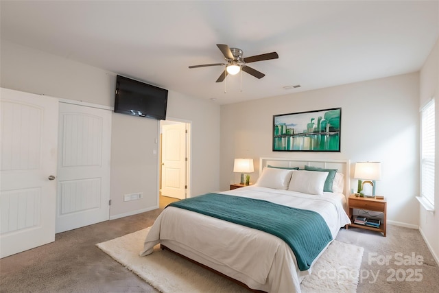carpeted bedroom featuring baseboards, ceiling fan, and visible vents