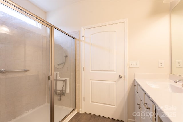 bathroom with a shower stall, wood finished floors, and vanity