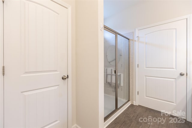 full bath with a stall shower and wood finished floors