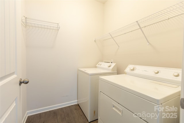 laundry area featuring dark wood finished floors, baseboards, separate washer and dryer, and laundry area