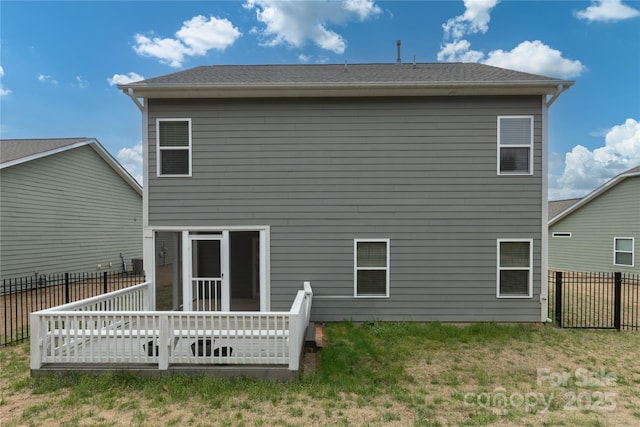 back of property with a fenced backyard, a shingled roof, and a yard