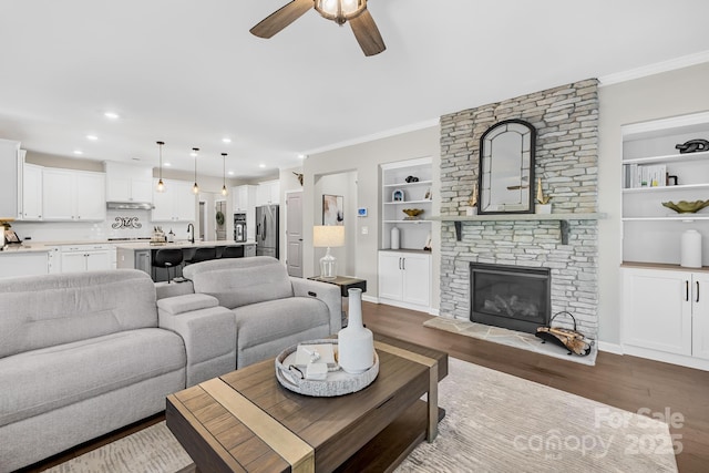 7313 Glenroe Dr, Huntersville, NC 28078 - living room with ceiling fan, dark wood finished floors, ornamental molding, built in features, and recessed lighting