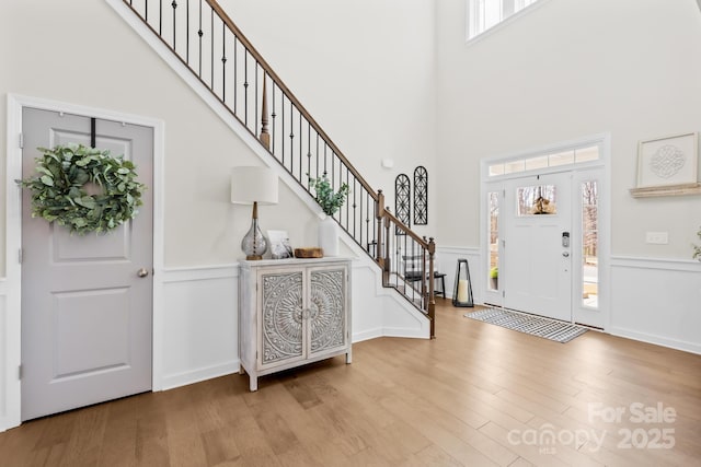 7313 Glenroe Dr, Huntersville, NC 28078 - entryway with a towering ceiling, wood finished floors, stairway, a decorative wall, and a wainscoted wall