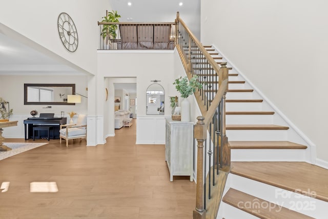 7313 Glenroe Dr, Huntersville, NC 28078 - stairway featuring wood finished floors, wainscoting, a high ceiling, recessed lighting, and a decorative wall