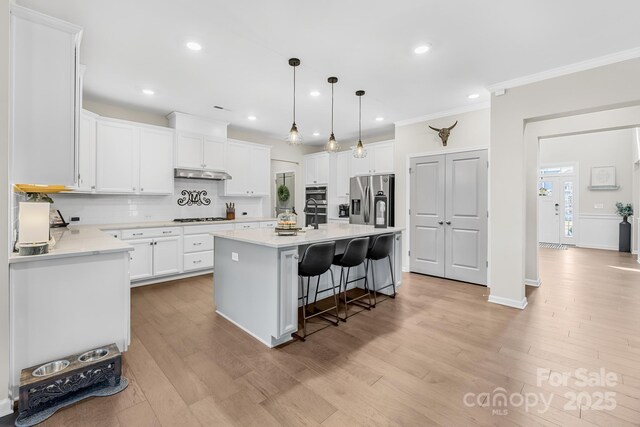 7313 Glenroe Dr, Huntersville, NC 28078 - kitchen featuring stainless steel appliances, ornamental molding, light countertops, a breakfast bar, and tasteful backsplash