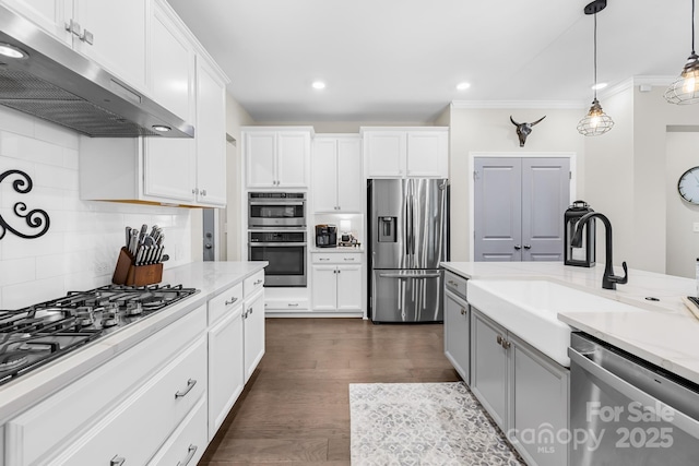 7313 Glenroe Dr, Huntersville, NC 28078 - kitchen with appliances with stainless steel finishes, under cabinet range hood, a sink, tasteful backsplash, and white cabinets