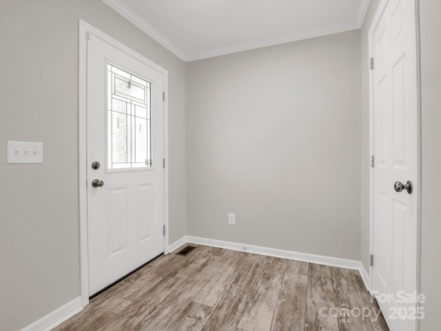 foyer entrance featuring baseboards, crown molding, and wood finished floors