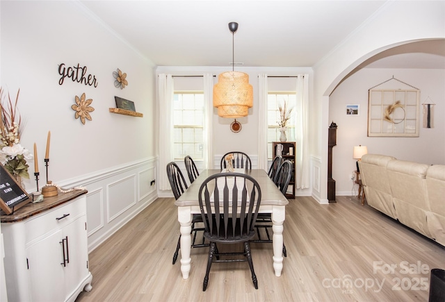 154 Rooster Tail Ln, Troutman, NC 28166 - dining area with arched walkways, light wood-style floors, ornamental molding, and wainscoting