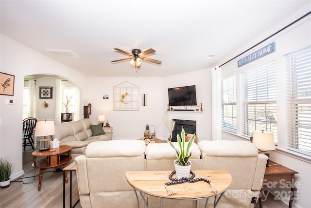 154 Rooster Tail Ln, Troutman, NC 28166 - living area featuring arched walkways, light wood finished floors, a ceiling fan, and healthy amount of natural light