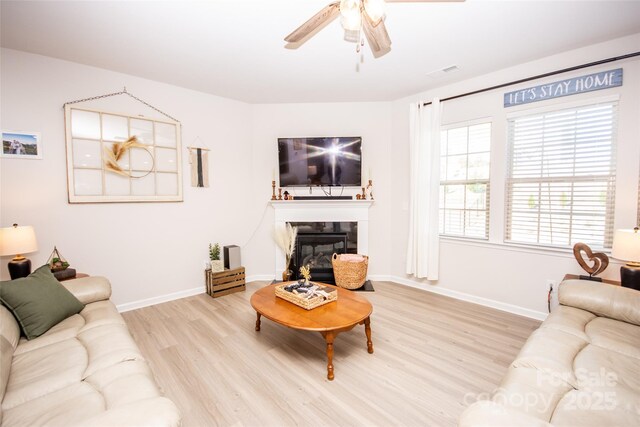 154 Rooster Tail Ln, Troutman, NC 28166 - living room featuring wood finished floors, ceiling fan, baseboards, and a glass covered fireplace
