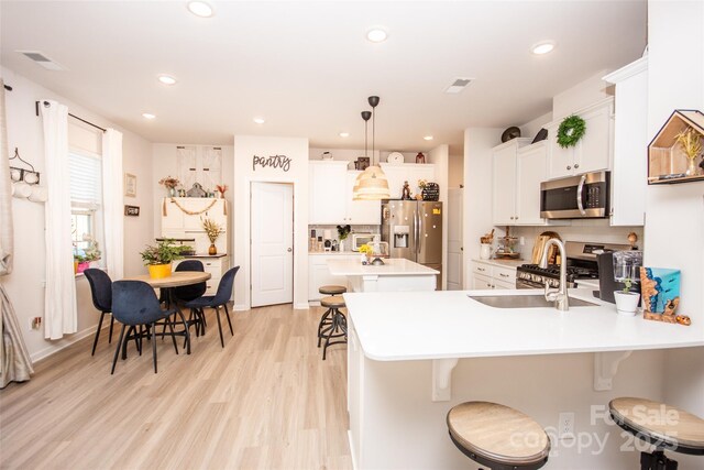 154 Rooster Tail Ln, Troutman, NC 28166 - kitchen featuring appliances with stainless steel finishes, a kitchen bar, light countertops, backsplash, and recessed lighting