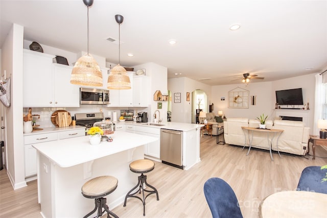 154 Rooster Tail Ln, Troutman, NC 28166 - kitchen featuring stainless steel appliances, open floor plan, a peninsula, a sink, and light countertops