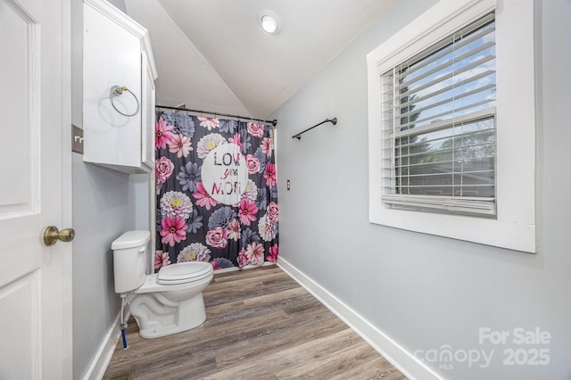 128 Allenton St, Norwood, NC 28128 - full bath featuring vaulted ceiling, toilet, curtained shower, wood finished floors, and baseboards