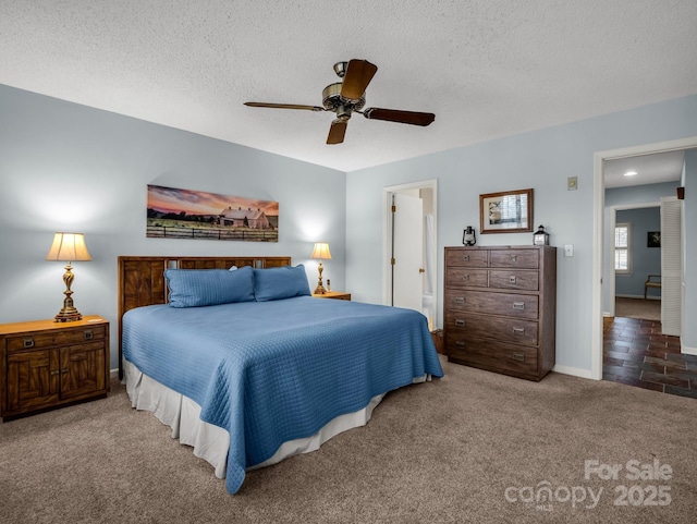 carpeted bedroom featuring baseboards, a textured ceiling, and a ceiling fan