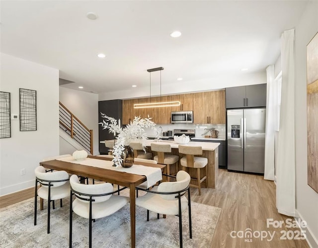 dining area with stairway, baseboards, light wood-style floors, and recessed lighting