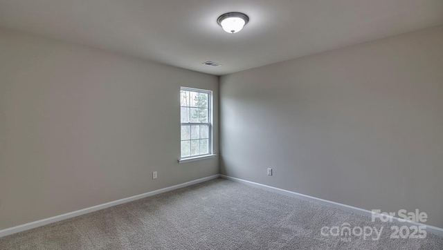 empty room featuring baseboards, carpet floors, and visible vents