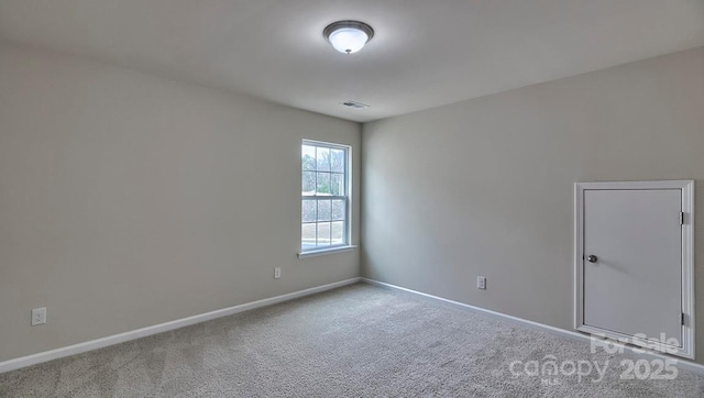 carpeted empty room featuring baseboards and visible vents