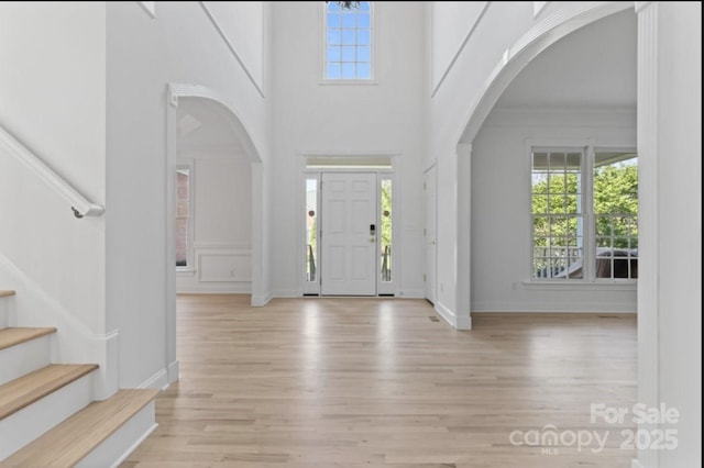 15009 Lisha Ln, Charlotte, NC 28277 - entrance foyer featuring wood finished floors, arched walkways, a towering ceiling, and stairway