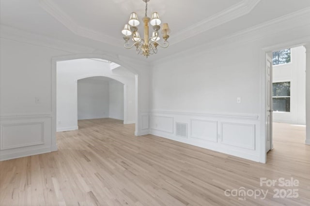 15009 Lisha Ln, Charlotte, NC 28277 - unfurnished dining area featuring a tray ceiling, light wood-type flooring, arched walkways, visible vents, and a notable chandelier