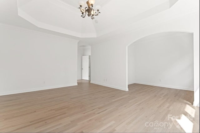 15009 Lisha Ln, Charlotte, NC 28277 - unfurnished room featuring crown molding, a raised ceiling, arched walkways, light wood-style floors, and an inviting chandelier