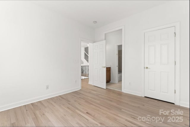 15009 Lisha Ln, Charlotte, NC 28277 - unfurnished bedroom with baseboards, light wood-style floors, and ensuite bathroom