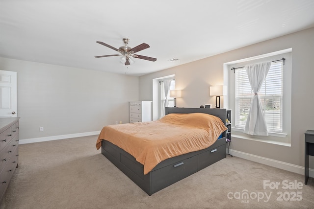 bedroom featuring baseboards, visible vents, a ceiling fan, and light colored carpet