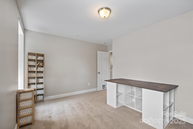 spare room with baseboards and light colored carpet