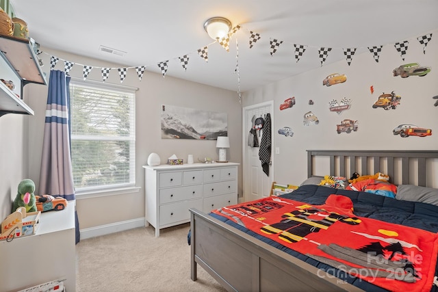 bedroom with baseboards, visible vents, and light carpet
