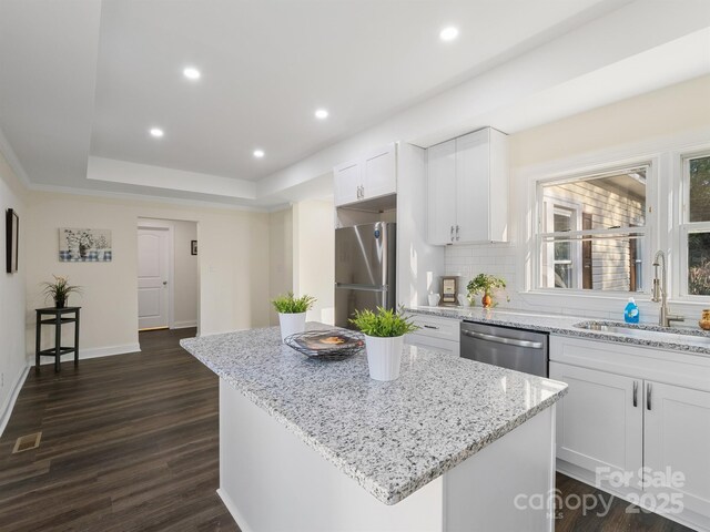 kitchen featuring dark wood-style flooring, white cabinets, visible vents, appliances with stainless steel finishes, and a sink