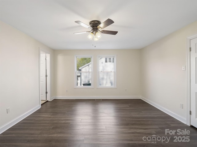 empty room with dark wood-type flooring, ceiling fan, and baseboards