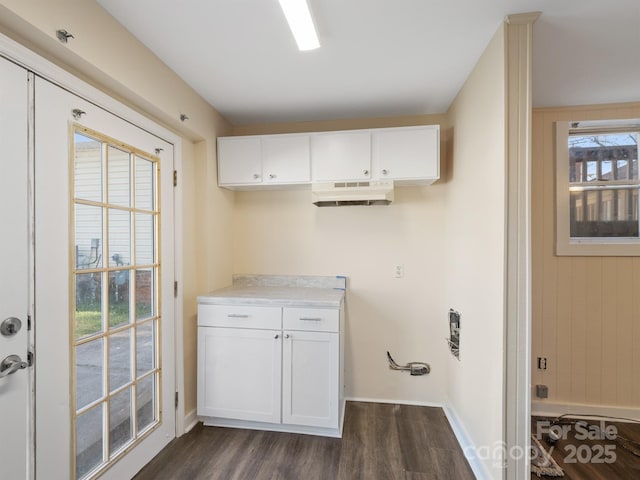 clothes washing area featuring dark wood finished floors and baseboards