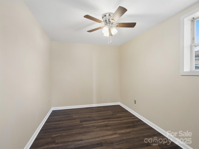 spare room with dark wood-type flooring, baseboards, and ceiling fan