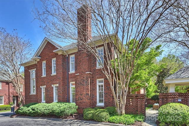 exterior space featuring brick siding and a chimney