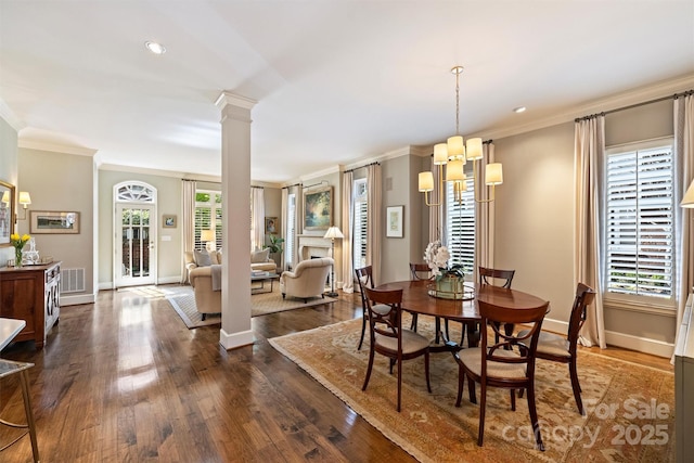 dining area with decorative columns, dark wood-style flooring, ornamental molding, and baseboards