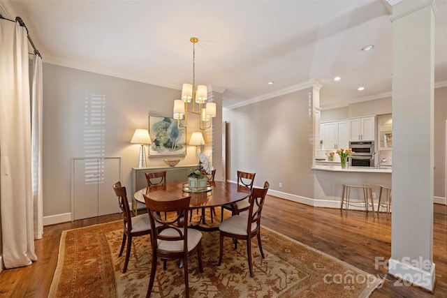 dining area with baseboards, wood finished floors, an inviting chandelier, and crown molding