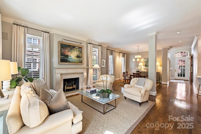 living area featuring dark wood finished floors, baseboards, a tiled fireplace, and ornamental molding