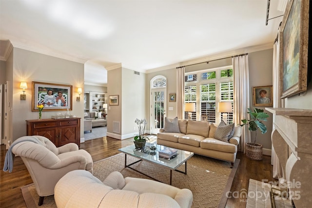 living room with visible vents, ornamental molding, baseboards, and wood finished floors