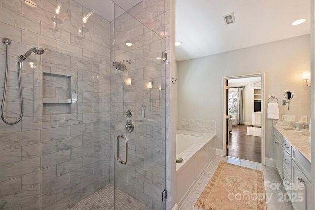 bathroom with visible vents, a shower stall, baseboards, vanity, and a garden tub