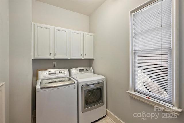 laundry area featuring baseboards, cabinet space, and washer and clothes dryer