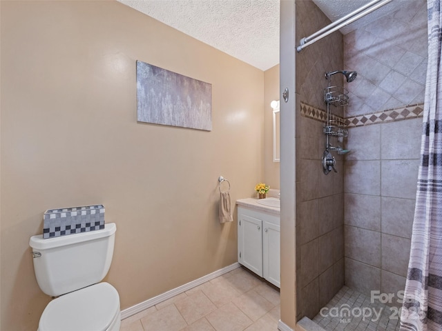full bathroom featuring vanity, tile patterned flooring, toilet, baseboards, and tiled shower