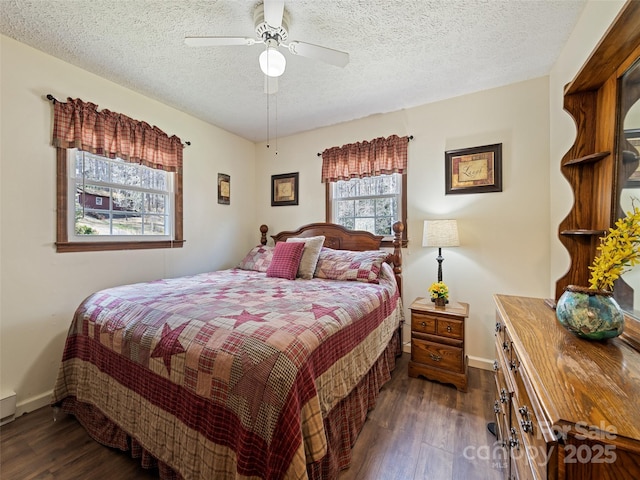 bedroom with dark wood-type flooring, a textured ceiling, baseboards, and ceiling fan