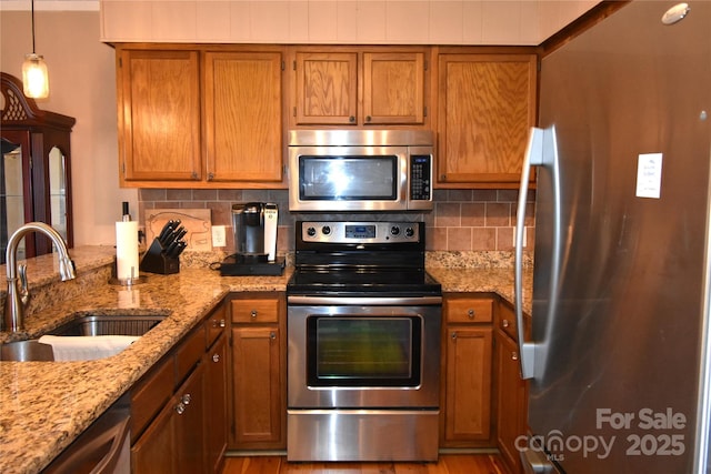 301 Pinnacle Inn Rd Unit 3219, Beech Mountain, NC 28604 - kitchen featuring appliances with stainless steel finishes, a sink, brown cabinetry, and decorative backsplash