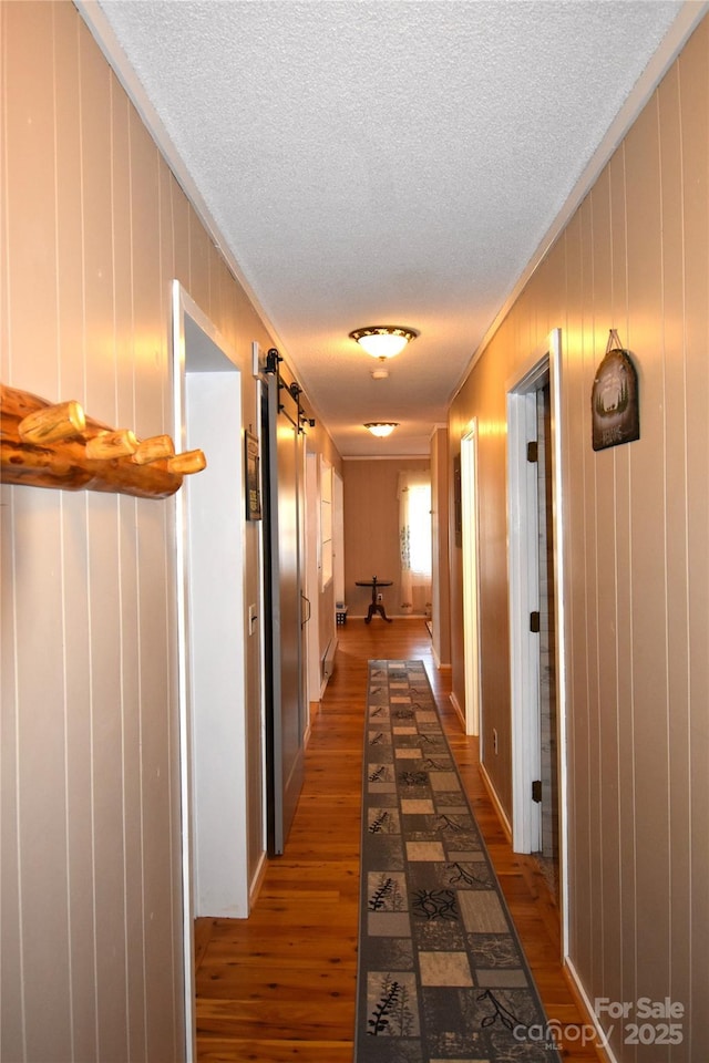 301 Pinnacle Inn Rd Unit 3219, Beech Mountain, NC 28604 - corridor featuring ornamental molding, wood finished floors, a textured ceiling, a barn door, and wooden walls