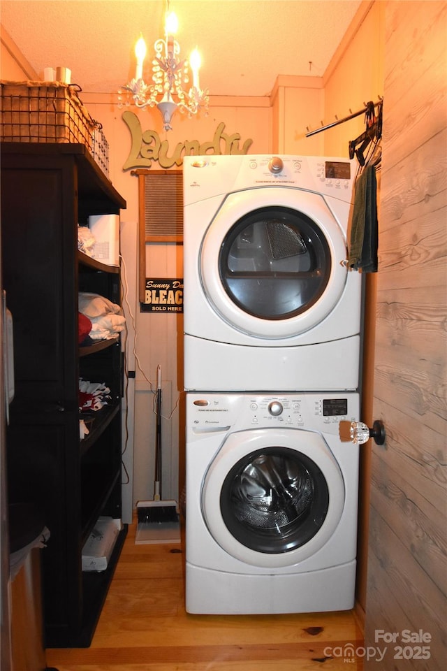 301 Pinnacle Inn Rd Unit 3219, Beech Mountain, NC 28604 - laundry area featuring estacked washer and dryer, a chandelier, light wood-type flooring, and wooden walls