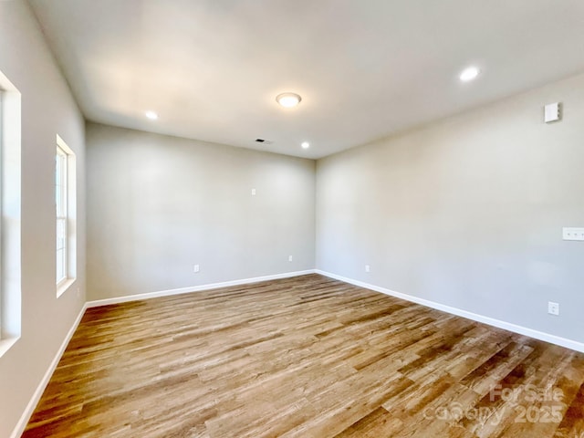 spare room featuring recessed lighting, visible vents, baseboards, and wood finished floors