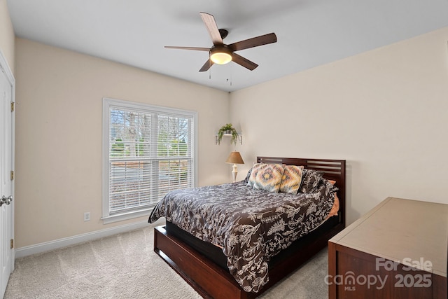 carpeted bedroom featuring baseboards and a ceiling fan