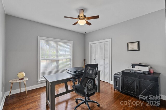 office area featuring baseboards, ceiling fan, and dark wood-type flooring