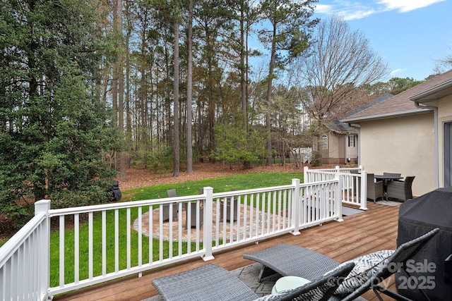 deck featuring outdoor dining space and a lawn