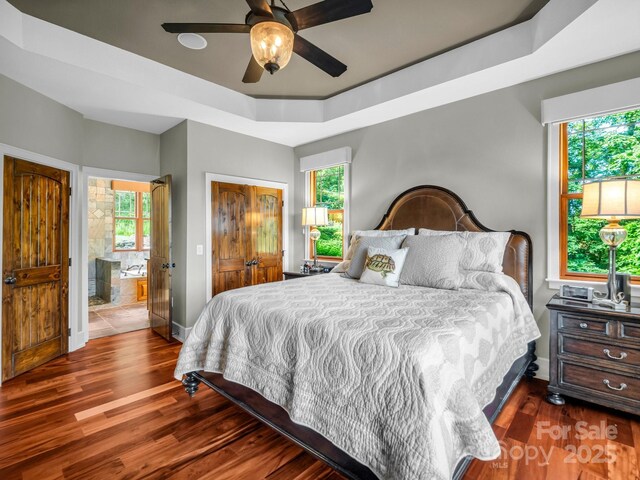 556 High Pines Loop, Lake Lure, NC 28746 - bedroom with wood finished floors, baseboards, a tray ceiling, and ensuite bath